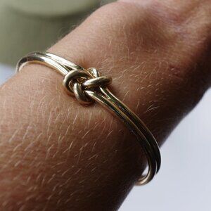Women`s gold tone knot cuff bracelet. 2 1/2in. ID